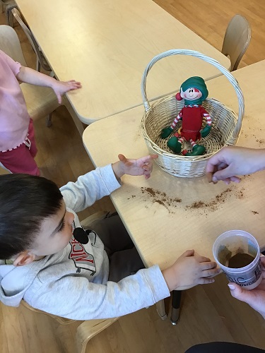 A child sprinkling magic dust onto the elf