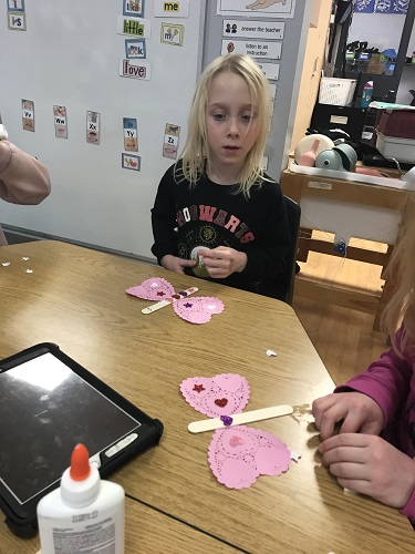 Children creating Valentine's crafts