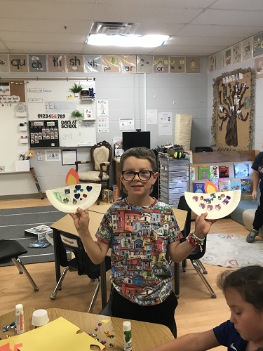 A child holding up the Diya's he created