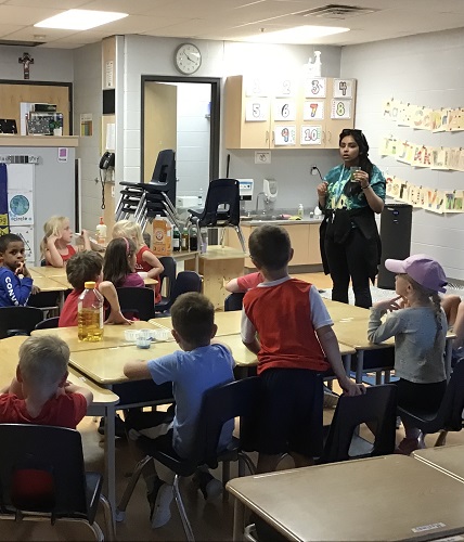 An educator talking with a group of children about what might happen with their experiment