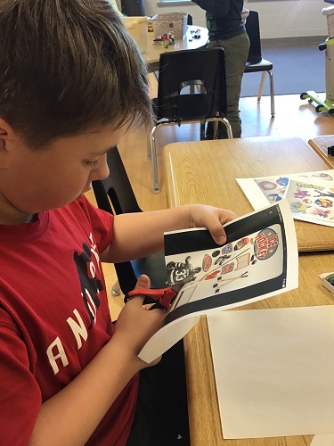 A child cutting out paper images