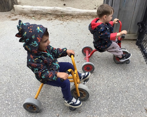 Two toddlers riding tricycles