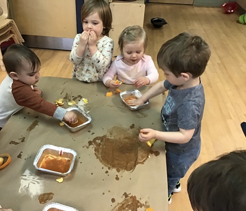Toddlers painting with orange water