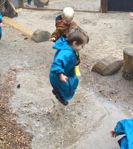 Toddlers jumping in puddles