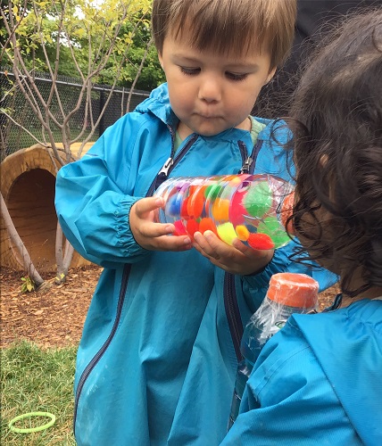 Toddler looking at sensory bottle