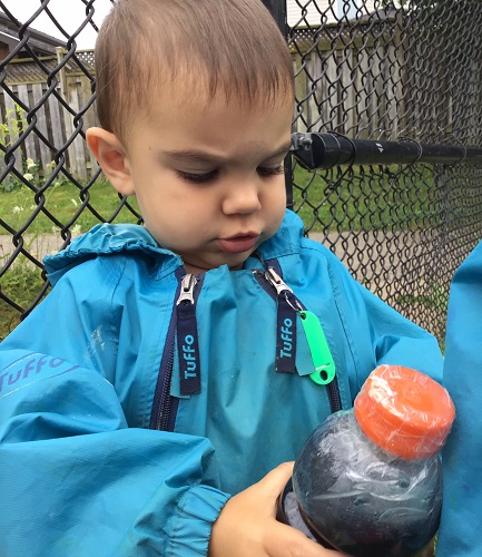 Toddler looking at a sensory bottle